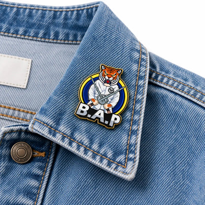 Custom hard enamel logo pin displayed on a denim jacket